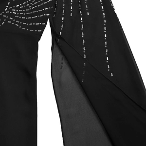 Detail of elegant black sheer fabric featuring silver rhinestones and a high side slit
