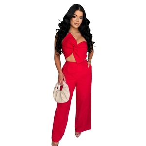 Detail of red two-piece set featuring a halter bow top and high-waist wide-leg pants