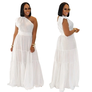 Détail de robe longue blanche à une épaule, taille élastique et volants en coton texturé