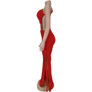 Détail latéral de la robe longue plissée rouge avec fentes latérales et cordes tressées