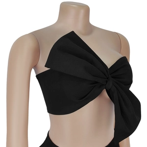 Detail of a black strapless crop top with a large decorative 3D bow on the front