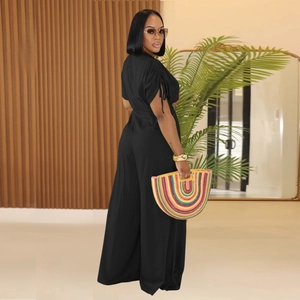 Detail view of black V-neck wide leg jumpsuit with drawstring pleated sleeve accents