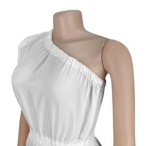 Détail d'une robe blanche à une épaule avec taille froncée et texture en coton doux