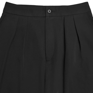 Detailed close-up of high-waist black trousers with single button and pleated design