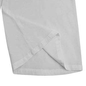 Gros plan sur les coutures précises et le tissu uni blanc de cette combinaison chic