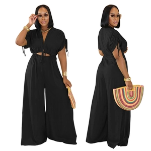 Detail of V-neck black wide-leg jumpsuit with waist cut-outs and lace-up design