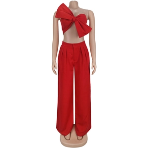 Detail of red two-piece set featuring oversized bow crop top and high waist wide leg pants