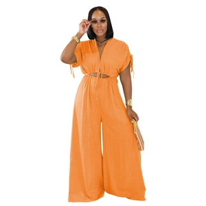 Detail of bright orange V-neck jumpsuit with waist cutout and drawstring tie detail