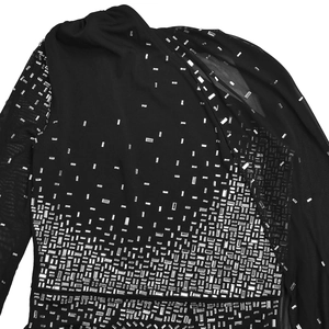 Détail d'une robe moulante noire avec strass argentés et manches en maille filet