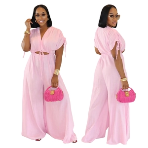 Detail of pink cotton jumpsuit featuring V-neck, waist cutout, and wide-leg design