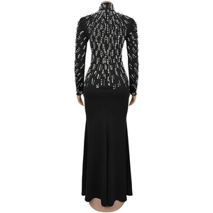 Detail of elegant black long sleeve evening gown featuring intricate white pearl embellishments