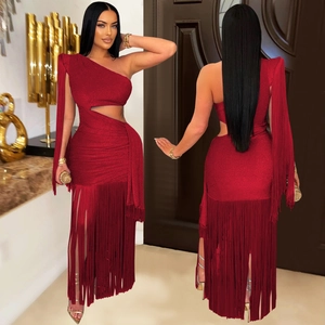 Détails d'une robe rouge à une épaule en tissu scintillant avec de longues franges