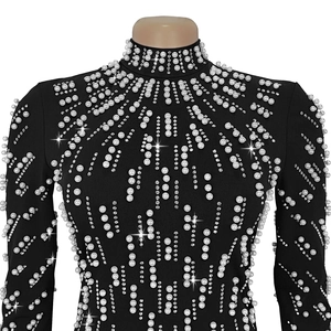 Detail shot of black bodycon dress featuring luxury beaded pearls and sparkling rhinestones