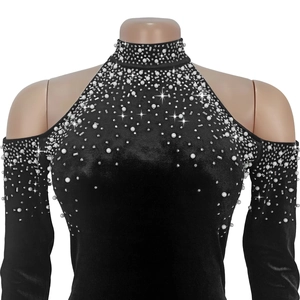 Détail de robe en velours noir avec perles et strass sur l'encolure aux épaules dénudées