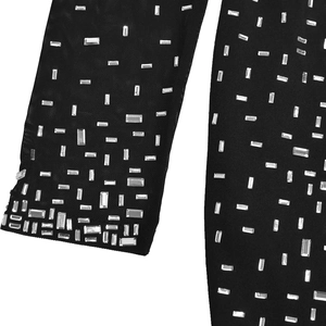 Détail du tissu en maille noire orné de strass argentés brillants et scintillants