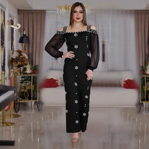 Elegante abito da sera nero con spalle scoperte, maniche in mesh e ricamo di perle