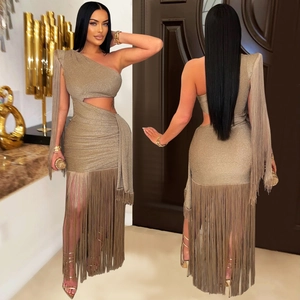 Détail d'une robe dorée champagne à une épaule avec de longues franges et découpe latérale
