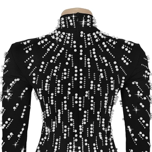 Detail of beaded pearls and crystals on the back of a black long-sleeve evening gown