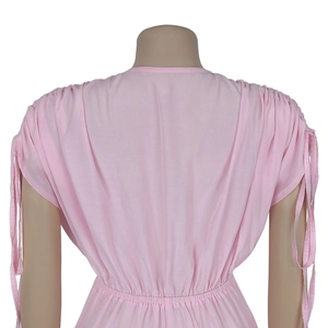 Detail of light pink jumpsuit featuring an elastic pleated waist and drawstring sleeve cuffs