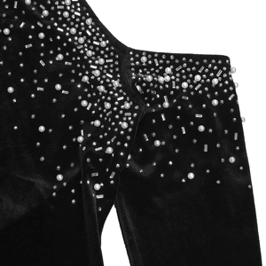 Détail d'une robe en velours noir avec perles blanches luxueuses et strass étincelants