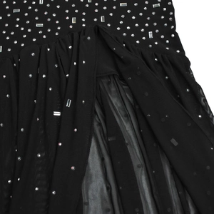 Detail of black mesh dress featuring sparkling rhinestones and elegant pleated waistline