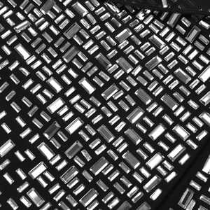 Détail macro de strass argentés étincelants sur une robe en maille noire de luxe