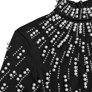 Detail of beaded pearls and silver rhinestones on a black high-neck long-sleeve dress