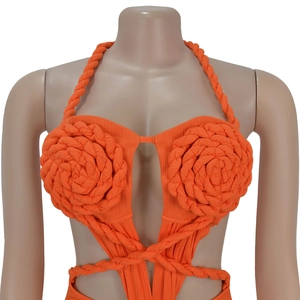 Detail of orange crochet halter swimsuit with large handmade flowers and ribbed texture