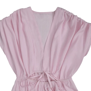 Detail of pale pink V-neck jumpsuit with silky fabric and drawstring waist tie