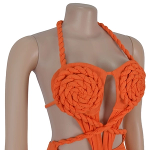 Detailed macro view of woven orange floral design and ribbed texture on dress