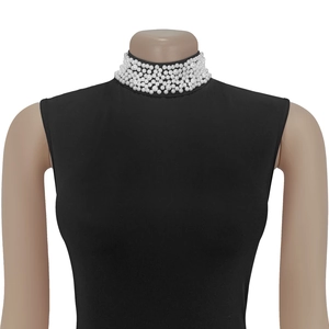 Detail of multi-layer white pearl choker necklace displayed on a black turtleneck