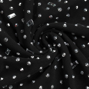 Macro detail of black mesh fabric with sparkling round and rectangular rhinestones