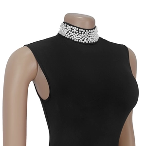 Detail of elegant black sleeveless turtleneck top featuring layered pearl beaded neckline