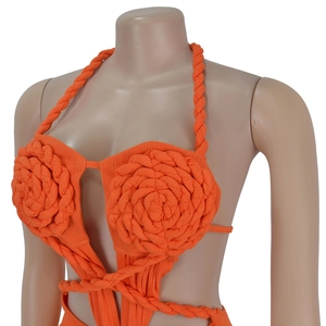 Detailed view of orange knit halter top with 3D braided flowers and thick straps