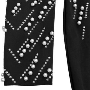 Detailed macro view of elegant pearl and rhinestone embellishments on black sleeve fabric