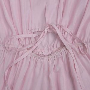 Detailed view of pink jumpsuit featuring elastic shirring and a stylish cut-out waist tie
