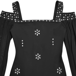 Dettaglio dell'abito nero con maniche in mesh e decorazioni floreali in strass argentati