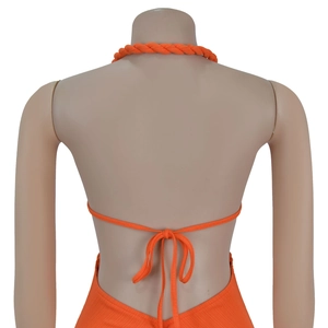 Detail view of orange ribbed knit halter dress with back tie string and woven texture