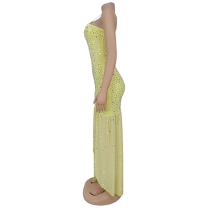 Detail of light yellow fish-tail maxi dress with sparkling silver rhinestones on a mannequin