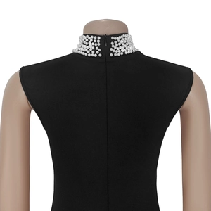 Close-up of back invisible zipper and white pearls on black sleeveless pleated dress