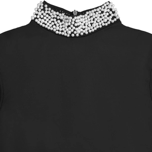 Detail of high neck black dress with multi-layered white pearls and back zipper