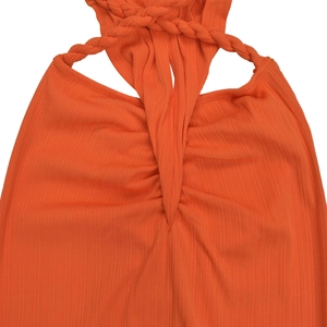 Macro detail of ribbed orange knit fabric featuring braided straps and twist knot design
