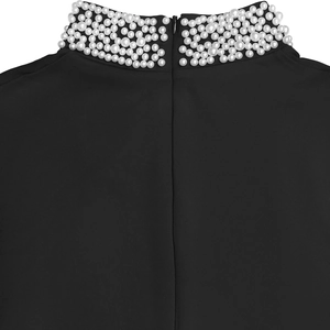 Detail of high neck black dress with white pearls and hidden zipper closure on the back