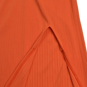 Detail shot of bright orange rib-knit fabric featuring a clean V-split hem design