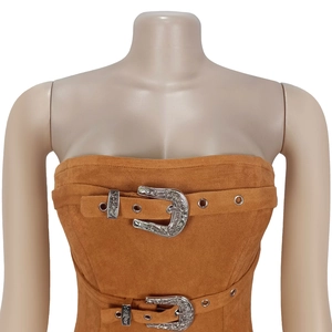 Détail d'un haut bandeau en daim marron avec ceintures style western et boucles gravées