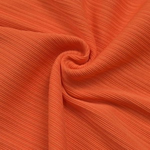 Macro detail of vibrant orange ribbed knit fabric showing texture and soft material