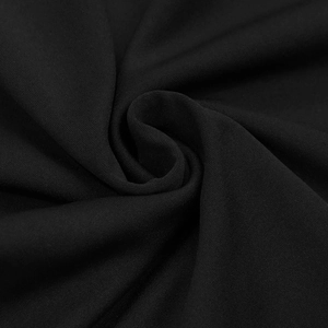 Macro detail of the premium black knitted fabric texture with a soft drape and refined grain