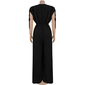 Detail view of black V-neck jumpsuit with waist elastic and cuff tie ribbons on the back