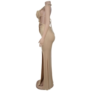 Detail of beige knit maxi dress with woven halter neck design and side slit feature