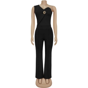 Detail showing the one-shoulder neckline with a round gold buckle on a black slim jumpsuit
